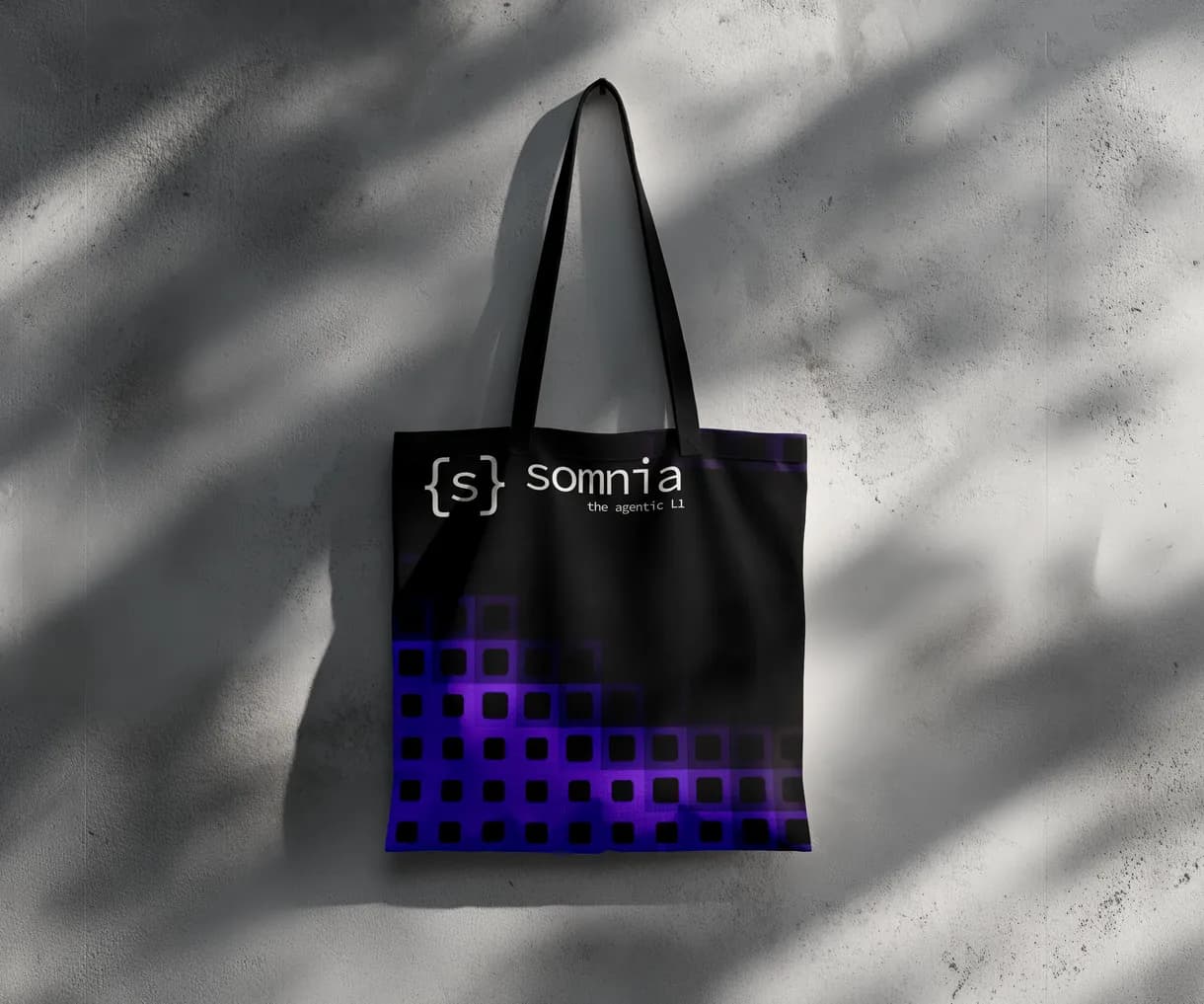 Black Somnia tote bag on a sunlit wall