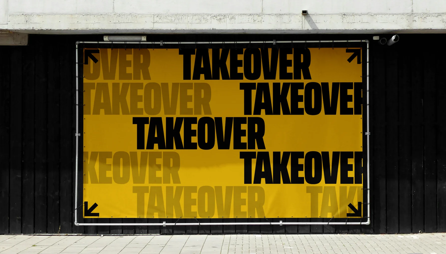 Takeover billboard on a black wall, the name repeated in yellow and black