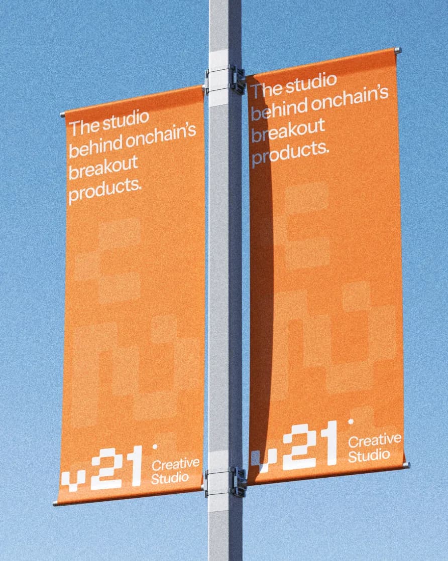 Orange V21 banners on a lamp post against a blue sky